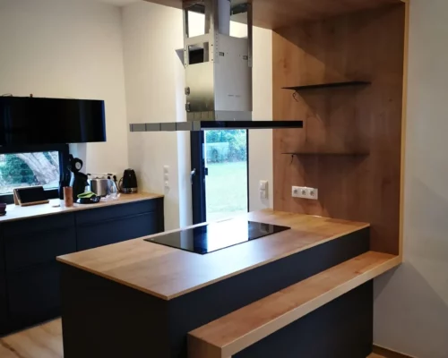 Schwarze Küche mit Holzarbeitsplatte